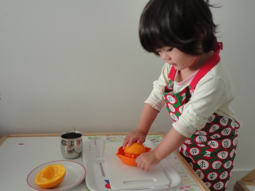toddler squeezing orange juice